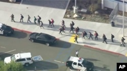 People are lead out of Saugus High School after reports of a shooting on Thursday, Nov. 14, 2019 in Santa Clarita, Calif. (KTTV-TV via AP)