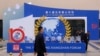 FILE - Workers walk past the entrance to the venue hosting the Xiangshan Forum in Beijing, China, Oct. 29, 2023.