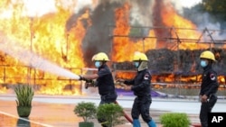 Firefighters spray water as flames and smoke rise from burning illegal drugs during a destruction ceremony to mark International Day Against Drug Abuse and Illicit Trafficking outside Yangon, Myanmar, June 26, 2020. 