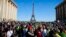 French "yellow vest" protesters, with the Eiffel Tower in the background, rally in support of an older female activist injured in a recent confrontation with police, March 30, 2019, in Trocadero Square, in Paris.