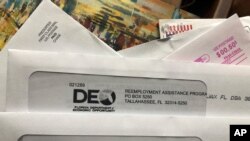 Envelopes from the Florida Department of Economic Opportunity Reemployment Assistance Program are shown, Nov. 5, 2020, in Surfside, Florida.