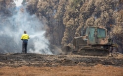 An Australian Army combat engineer from the 5th Engineer Regiment utilizes a JD-450 Bulldozer to spread out burnt woodchip at the Eden Woodchip Mill in southern New South Wales, Australia, in support of Operation Bushfire Assist, Jan. 11, 2020.