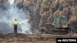 An Australian Army combat engineer from the 5th Engineer Regiment uses a bulldozer to spread out burned wood chips at the Eden Woodchip Mill in southern New South Wales, Australia, in support of Operation Bushfire Assist, Jan. 11, 2020.