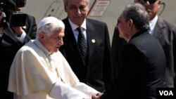 Paus Benediktus XVI disambut Presiden Kuba, Raul Castro di bandara kota Santiago hari Senin (26/3).