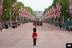 FILE - Troops marching down the Mall to Horse Guards parade to take part in the Trooping the Color parade at Buckingham Palace in London, June 17, 2023.