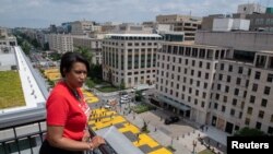 FILE - Mayor Muriel Bowser looks out over a Black Lives Matter sign that was painted on a street, during nationwide protests against the death in Minneapolis police custody of George Floyd, in Washington, D.C., June 5, 2020. 