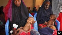 Dua orang ibu menggendong bayinya yang kurang gizi - akibat bencana kekeringan parah di Somalia selatan - di sebuah kamp pengungsi di Mogadishu, Somalia akhir bulan lalu (foto: dok). 