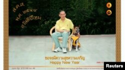 FILE - Thailand's King Bhumibol Adulyadej poses with his favorite dog, Khun Thongdaeng, in a New Year's greeting card addressed to the Thai people, Dec. 7, 2005.