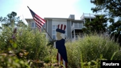 Sebuah boneka patriot dengan bendera AS dipasang setelah Presiden Joe Biden mengumumkan pengunduran dirinya dari pencalonan kembali dalam pilpres 2024, di Rehoboth Beach, Delaware, Minggu, 21 Juli 2024. (Foto: Ken Cedeno/Reuters)