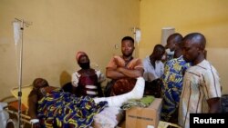 Relatives gather around one of the victims of the attack by gunmen during a Sunday mass service, as she receives treatment at the Federal Medical Centre in Owo, Ondo State, Nigeria. June 6, 2022