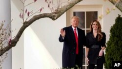 FILE - President Donald Trump waves with outgoing White House Communications Director Hope Hicks before boarding Marine One on the South Lawn of the White House in Washington, March 29, 2018.