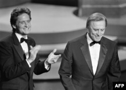 In this file photo taken on March 25, 1985, actor Michael Douglas applauds his father Kirk Douglas during the 57th Annual Academy Awards, in Hollywood.
