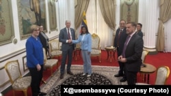 크리스 라이트 미국 에너지부 장관이 델시 로드리게스 베네수엘라 임시 대통령과 악수하고 있다.