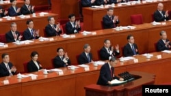 Chinese President Xi Jinping and other officials applaud as Premier Li Qiang concludes his work report at the opening session of the National People's Congress at the Great Hall of the People in Beijing, March 5, 2025. 