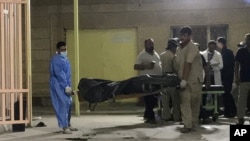 Hospital workers carry the body of a victim from a bus bombing into a morgue in the holy city of Karbala, Iraq, Sept. 20, 2019.