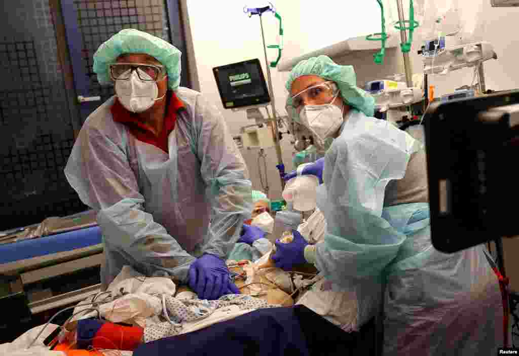 Doctor Katharina Franz and paramedic Andreas Hankel reanimate a patient during preparations for his transport in the special isolation chamber "IsoArk", for highly infectious COVID-19 patients, in Hanau, Germany, April 16, 2020.