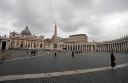 FILE - Few tourists walk in St. Peter's Square at the Vatican, March 6, 2020.