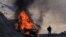A man stands near his burning car along the road to a mountain pass, near the border between Nagorno-Karabakh and Armenia, on Sunday, Nov. 8, 2020. 