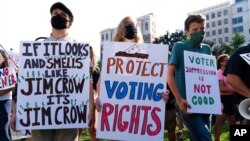 Demonstrators hold signs during a march for voting rights, marking the 58th anniversary of the March on Washington, Aug. 28, 2021, in Washington. 