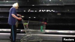 Una mujer busca queso en los estantes refrigerados de un supermercado en Caracas. La oposición dice que sus prioridad en el diálogo con el gobierno es atender la emergencia humanitaria