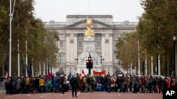 Climate protestors block the Mall leading to Buckingham Palace, rear, central London, Oct. 7, 2019.