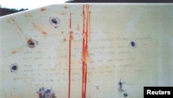 A blood-stained message that prosecutors say Boston Marathon bombing suspect Dzhokhar Tsarnaev wrote on the inside of a boat is seen with bullet holes in an undated evidence picture shown to jurors in Boston, March 10, 2015. 