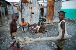 In this Dec. 3, 2019 photo, children play near their home in the Cite Soleil slum of Port-au-Prince, Haiti.