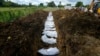 Un equipo forense entierra a un grupo de migrantes que murieron tratando de cruzar la brecha del Darién, en una fosa común en el cementerio de Guayabillo en Agua Fría, Panamá, el jueves 30 de septiembre de 2021. 