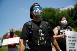 Protesters wear face masks to protect against the spread of the new coronavirus as they gather in Lafayette Square, June 13, 2020, near the White House in Washington, while demonstrating against the death of George Floyd.