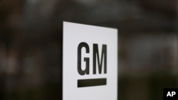 FILE - This May 16, 2014, file photo, shows the General Motors logo at the company's world headquarters in Detroit. GM is suing Fiat Chrysler, alleging that its crosstown rival got an unfair business advantage by bribing officials of the UAW. 