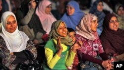 A girl in the women's section of the audience claps as she watches the filming of a new Islamic version of "American Idol," launched to promote and drum up talent for the Arab world's first Islamic pop music video in a bid to capitalize on a generation of