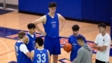 Olivier Rioux, back center, a 2.4-meter-tall college basketball player at Florida, gathers with coaches and teammates at the team's practice, Friday, Oct. 18, 2024, in Gainesville, Fla. (AP Photo/John Raoux)