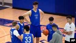 Olivier Rioux, back center, a 2.4-meter-tall college basketball player at Florida, gathers with coaches and teammates at the team's practice, Friday, Oct. 18, 2024, in Gainesville, Fla. (AP Photo/John Raoux)