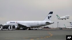 FILE - An Iranian Mahan Air passenger plane takes off as a plane of Iran's national air carrier, Iran Air, is parked at left, at Mehrabad airport in Tehran, Feb. 7, 2016.