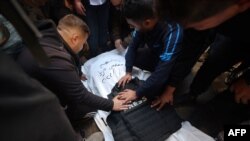 Para jurnalis berduka atas kematian rekan mereka, Mustafa Thuria, kamerawan untuk kantor berita AFP, yang tewas dalam serangan udara Israel, pada pemakamannya di Rafah di Jalur Gaza hari Minggu, 7 Januari 2024.