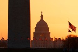 The Washington Monument and the U.S. Capitol are seen in Washington, at sunrise, March 18, 2020.