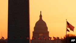 The Washington Monument and the U.S. Capitol are seen in Washington, at sunrise Wednesday, March 18, 2020. The White House has sent Congress an emergency $46 billion spending request for coronavirus-related funding this year. (AP Photo/Carolyn…