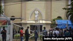 Polisi memeriksa lokasi di luar gereja pasca ledakan di Makassar pada 28 Maret 2021. (Foto: AFP/Indra Abriyanto)