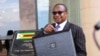Zimbabwe's Finance Minister Mthuli Ncube stands with a briefcase at the Parliament Building in Mt Hampden on the day he presents the 2024 National Budget, Harare