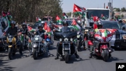 Bikers flying Jordanian flags during a rally celebrating the upcoming royal wedding in Amman, Jordan, May 30, 2023.