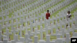 Children walk along layers of tombs as they attend Memorial Day ceremonies at the Manila American Cemtery and Memorial in suburban Taguig, south of Manila, Philippines on Sunday May 29, 2011. The cemetery site contains the largest number of U.S. military 