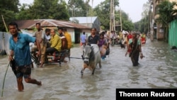 People move along a flooded road in Gaibandha, Bangladesh July 18, 2019. 