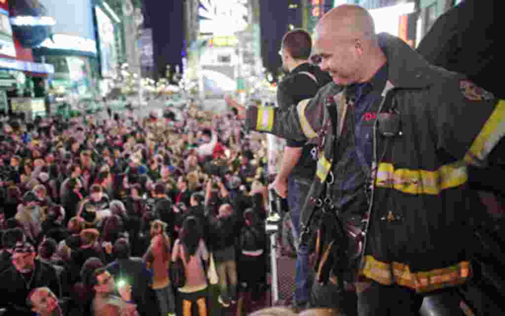 A firefighter waves to the crowd as people celebrate after Al Qaeda leader Osama bin Laden was killed in Pakistan, during a spontaneous celebration in New York's Times Square, May 2, 2011. Bin Laden was killed on Sunday in a firefight with U.S. forces in 