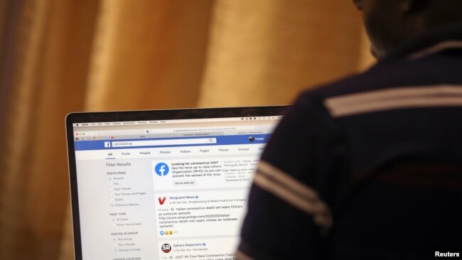 A man opens the Facebook page on his computer to fact check coronavirus disease (COVID-19) information, in Abuja, Nigeria March 19, 2020. Picture taken March 19, 2020. REUTERS/Afolabi Sotunde