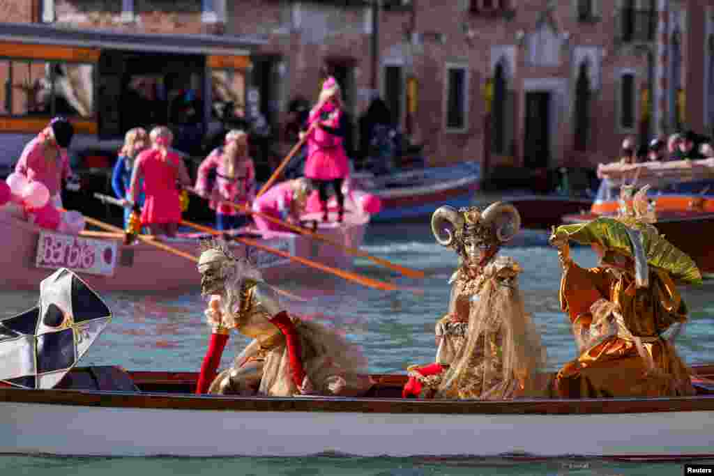 Revelers row during the masquerade parade on the Grand Canal during the Venice Carnival, in Venice, Italy.