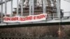 FILE - An activist hangs from a bridge to protest Iran's President Hassan Rouhani visit to Paris, January 28, 2016.