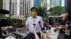 FILE - Pro-democracy activist Avery Ng gestures to the media before a trial over charges related to an unauthorized assembly on Oct. 1, 2019, outside the court in Hong Kong, May 17, 2021.