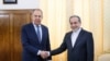 Menteri Luar Negeri Rusia Sergei Lavrov berjabat tangan dengan Menteri Luar Negeri Iran Abbas Araqchi selama pertemuan di Teheran, Iran, 25 Februari 2025. (Kementerian Luar Negeri Rusia/Handout via REUTERS)