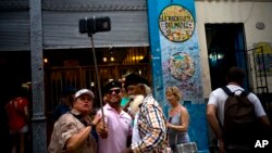 FILE - Tourists take a selfie at the Bodeguita Del Medio bar in Havana, Cuba, April 28, 2017.