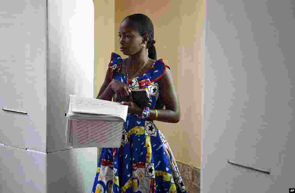 A woman carries her 56-page parliamentary ballot with 18,500 candidates to a ballot box at a polling station in Democratic Republic of Congo's capital Kinshasa, November 28, 2011. (Reuters)